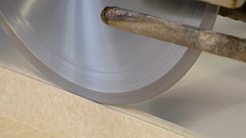 Close-up of a diamond saw cutting a quartz slab during fabrication.