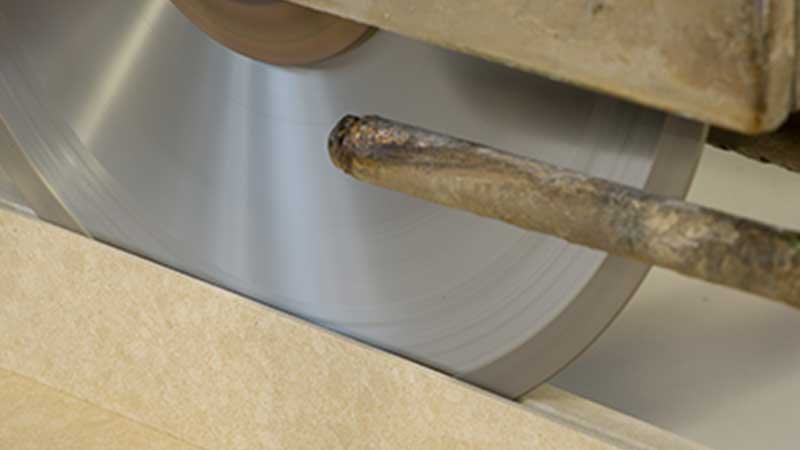 Close-up of a diamond saw cutting a quartz slab during fabrication.